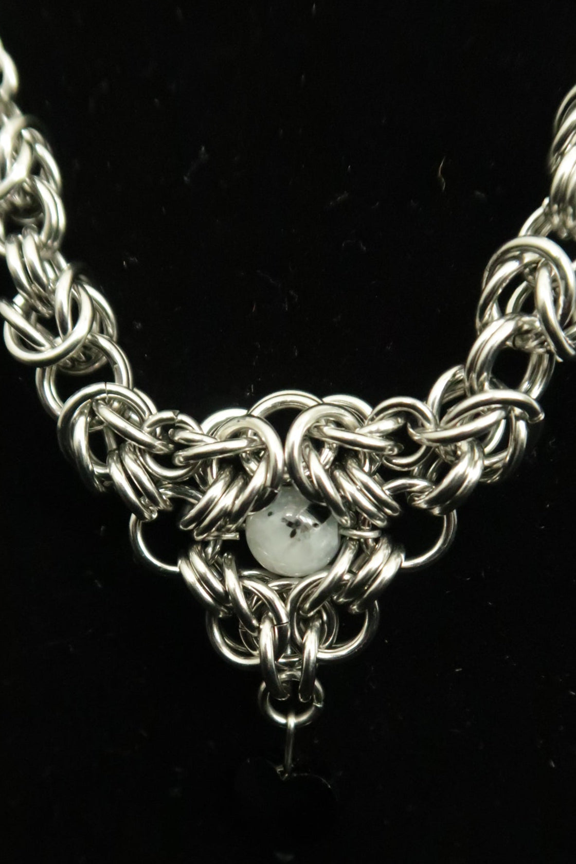 Close-up of a silver chain necklace on a dark background