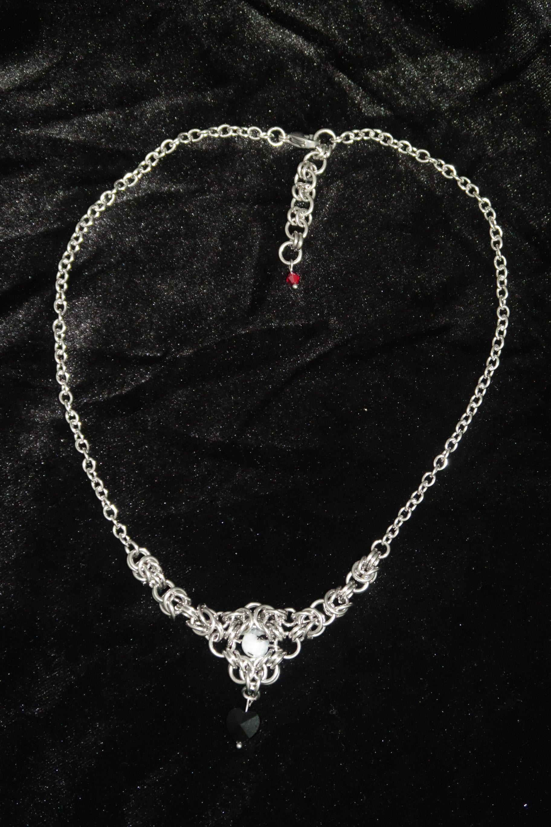 Silver chain necklace on a black velvet background