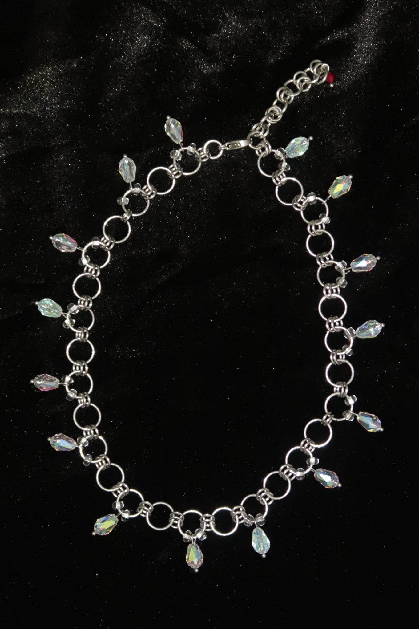 Silver necklace with gemstones on a black velvet background