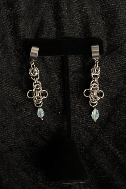 chain earrings with a dangling gemstone on a black background